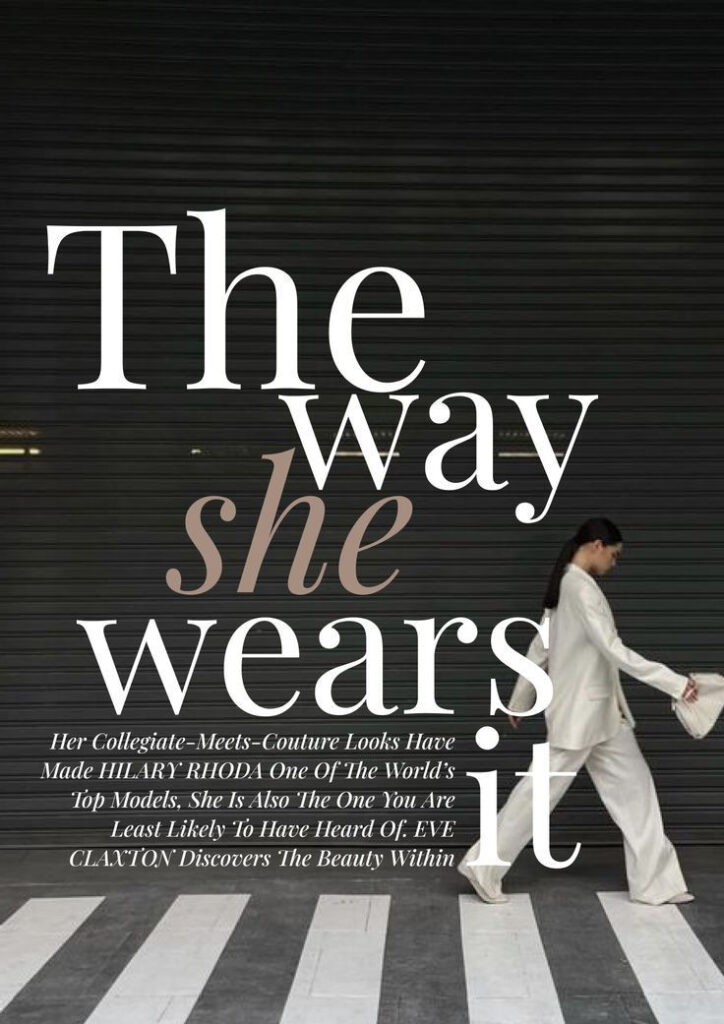 Stylish woman in white suit walks past large text The way she wears it on a dark background.