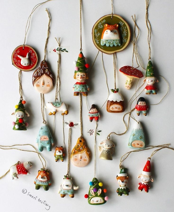 _ 12 Handcrafted Christmas ornaments with cute characters and festive designs hanging on strings. | Sky Rye Design Handcrafted Christmas ornaments with cute characters and festive designs hanging on strings.