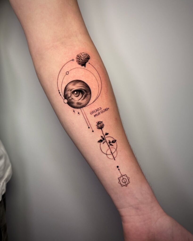 Forearm tattoo featuring an eye, celestial elements, brain, rose, and geometric designs on light skin.