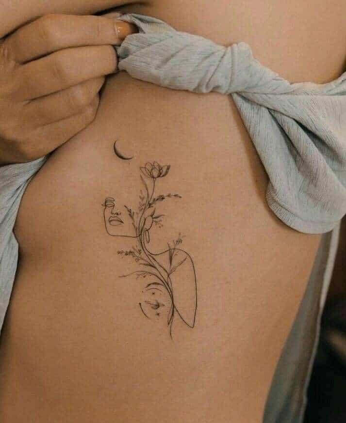 Minimalistic floral tattoo on side body, featuring abstract face and crescent moon design. Subtle and artistic in style.