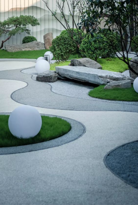 Modern garden with curvy paths, white spherical lights, manicured shrubs, and large stones. Serene and minimalist design.