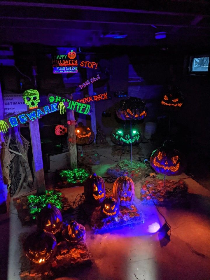 Spooky Halloween display with glowing pumpkins and signs, creating an eerie haunted house atmosphere.