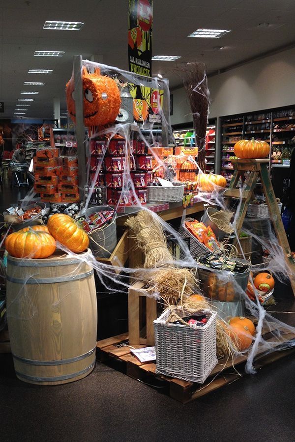 _ 16 Halloween-themed supermarket display with pumpkins, cobwebs, and festive decorations in store aisle. | Sky Rye Design Halloween-themed supermarket display with pumpkins, cobwebs, and festive decorations in store aisle.