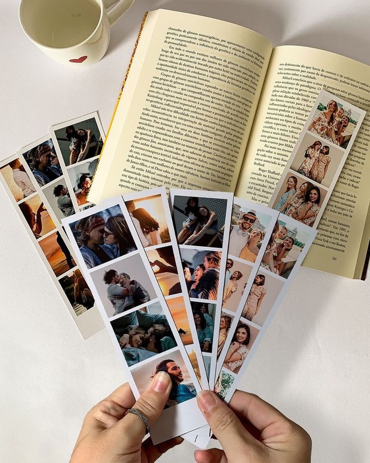 Open book with photo strips and a cup of tea, capturing joyful moments and memories.