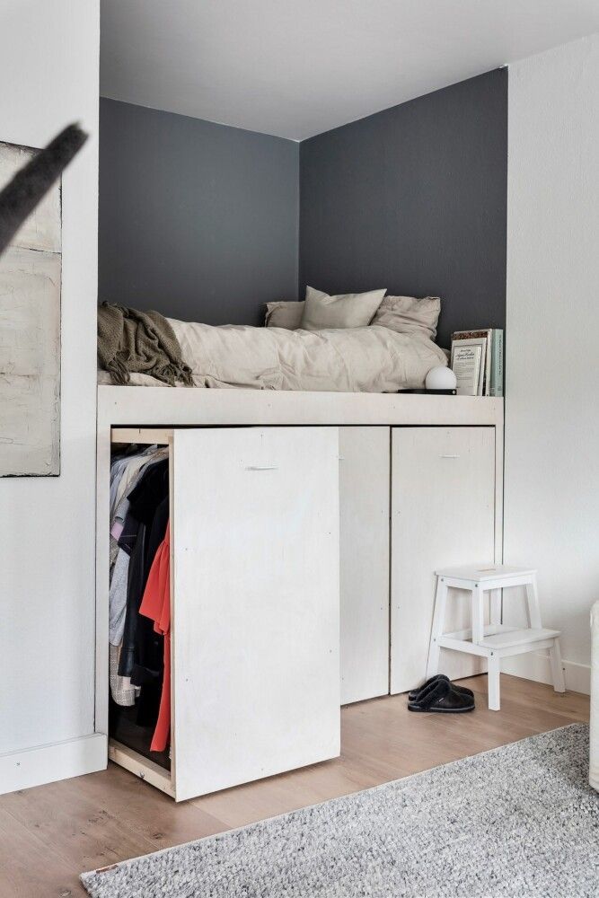 Loft bed with storage drawers underneath, featuring cozy bedding and a two-step stool in a modern bedroom setup.