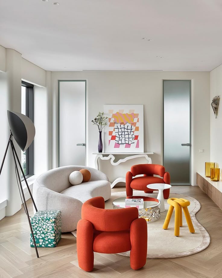 Modern living room with colorful chairs, abstract art, quirky decor, and large windows. Cozy and stylish interior design.