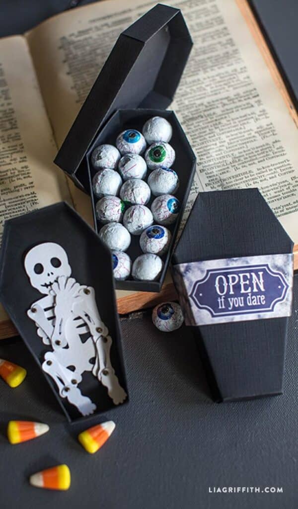 17 Frighteningly Good Halloween DIYs Halloween-themed candy display with eyeball chocolates and a skeleton in coffin-shaped boxes. | Sky Rye Design Halloween-themed candy display with eyeball chocolates and a skeleton in coffin-shaped boxes.