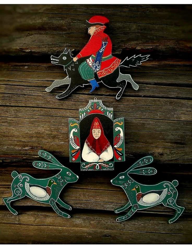 _ 18 Decorative art featuring a rider on a wolf, a cloaked figure, and two stylized rabbits on wooden background. | Sky Rye Design Decorative art featuring a rider on a wolf, a cloaked figure, and two stylized rabbits on wooden background.