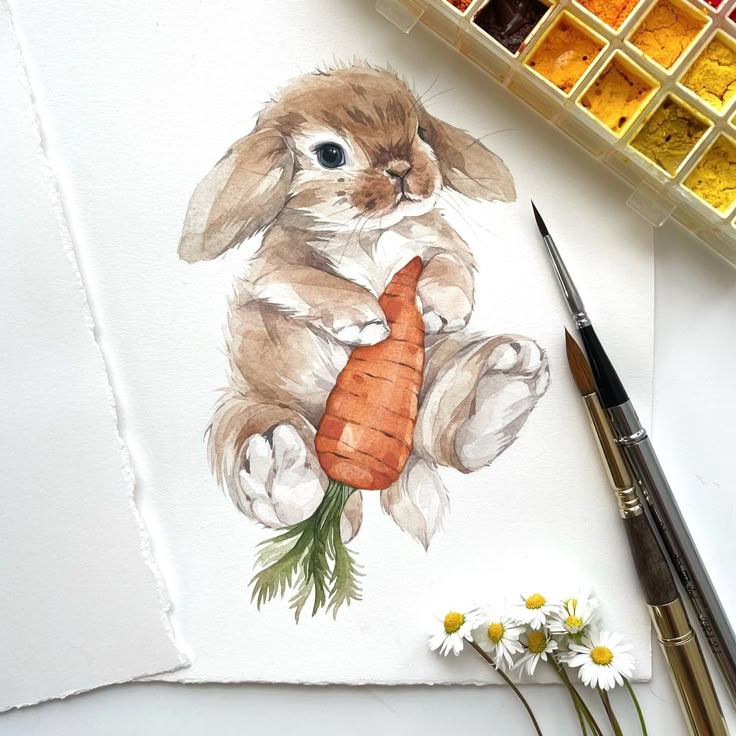Watercolor painting of a cute rabbit holding a carrot, surrounded by paintbrushes and daisies.
