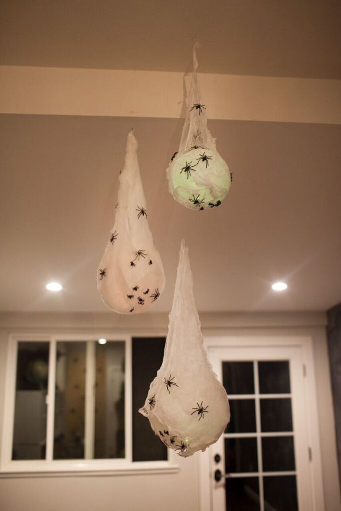 1cee26b5acd9febb2dfb976d04e7404f Halloween decoration with hanging spider cocoons in a room setting. | Sky Rye Design Halloween decoration with hanging spider cocoons in a room setting.