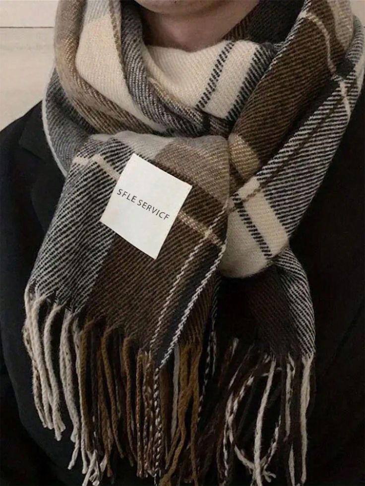 Close-up of a stylish plaid scarf in brown tones with a label, perfect for winter fashion and warmth.