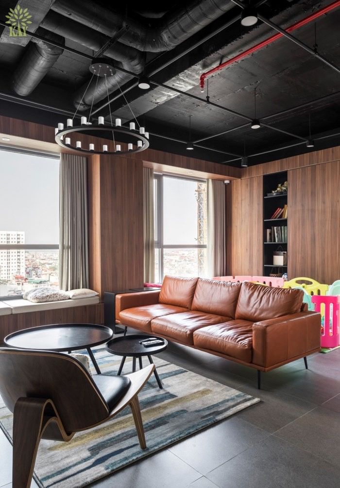 Modern living room with a leather sofa, wooden accents, and large windows for natural light.
