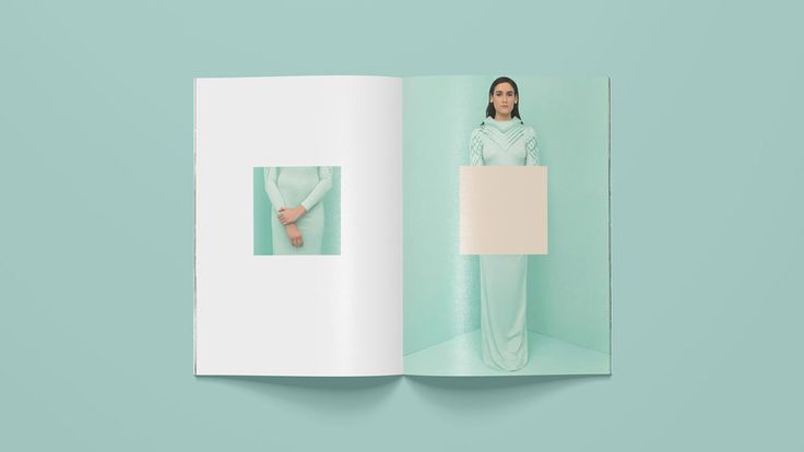 Open magazine with a woman in a white dress against a teal background, showcasing minimalist fashion photography.