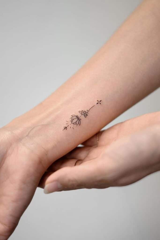 Minimalistic flower tattoo on forearm, small and delicate design with line art style.