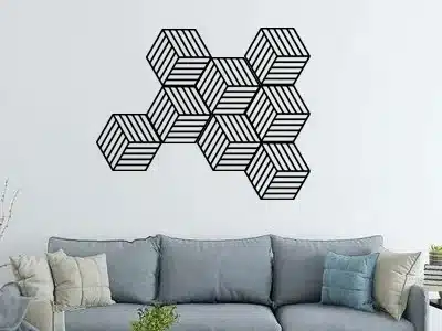 Geometric wall art above a modern grey sofa in a stylish living room with decorative pillows and a wooden coffee table.