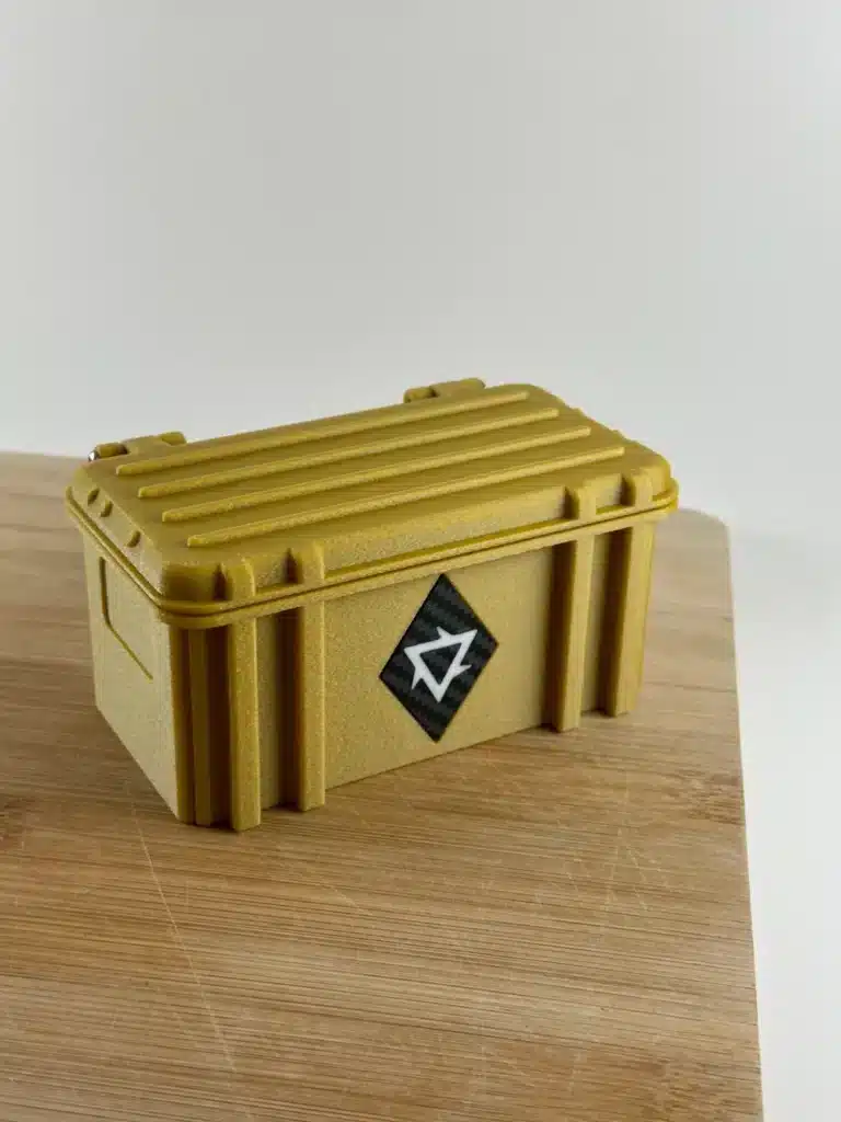 Gold protective case with geometric logo on wooden surface. Secure storage or transport solution.