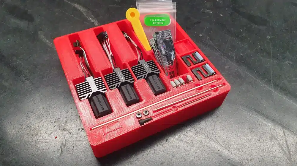3D printer upgrade kit in red case with wires, resistors, and components for enhanced printing performance.