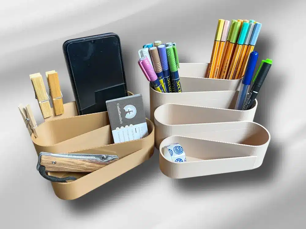 Desktop organizer with pens, phone, and stationery in modern, sleek compartments against a soft gray background.