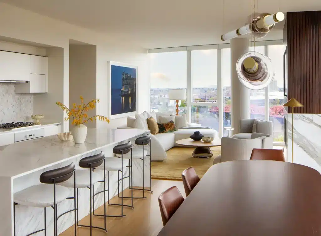 20240405_TheMorrisons_JHL_Condo_Italia_413-scaled Modern open-plan living room with elegant decor, marble kitchen island, cozy seating, and city views through large windows. | Sky Rye Design Modern open-plan living room with elegant decor, marble kitchen island, cozy seating, and city views through large windows.