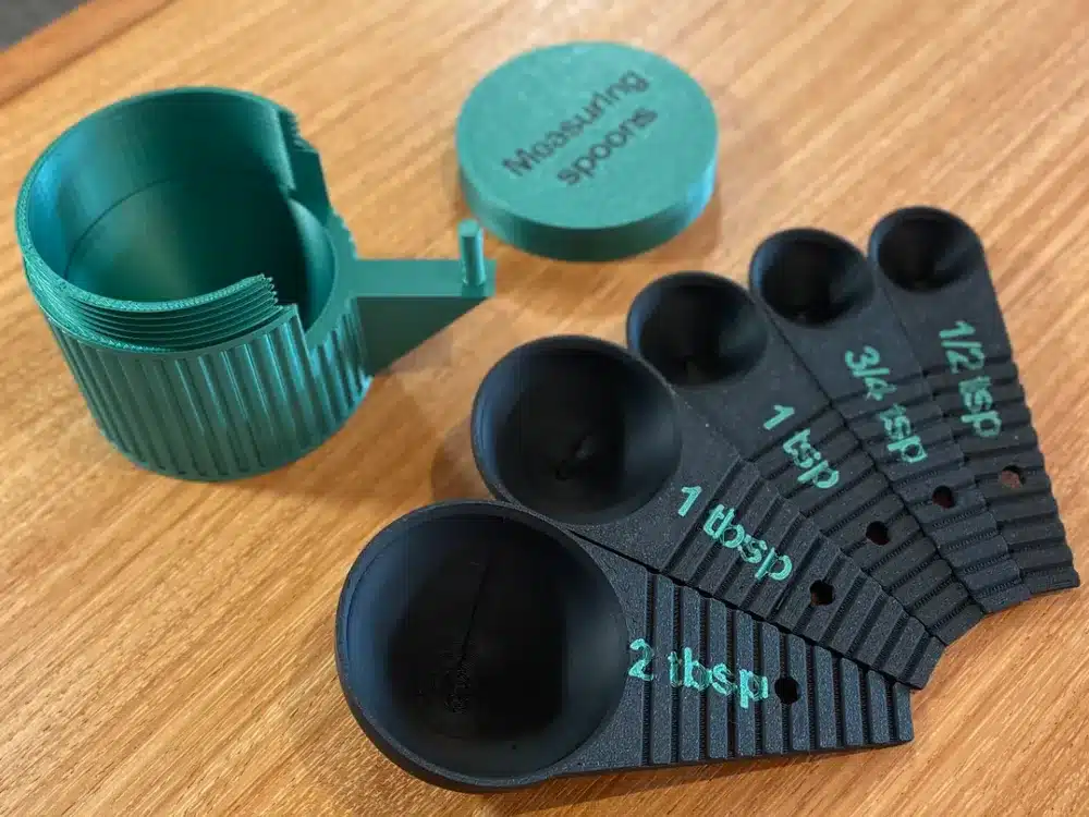 Custom 3D printed measuring spoons set on a wooden table, highlighting various teaspoon and tablespoon sizes.