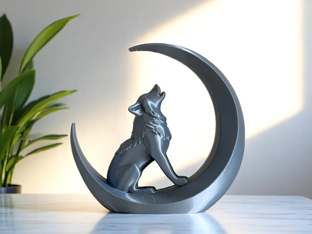 Sleek wolf sculpture howling on crescent moon, modern decor piece on tabletop with plant in background.