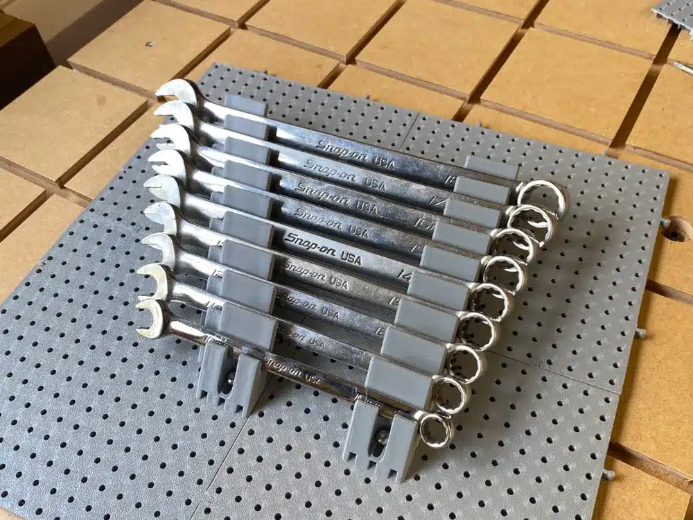 Set of Snap-on wrenches organized on a perforated board, ideal for professional tool storage and easy access.
