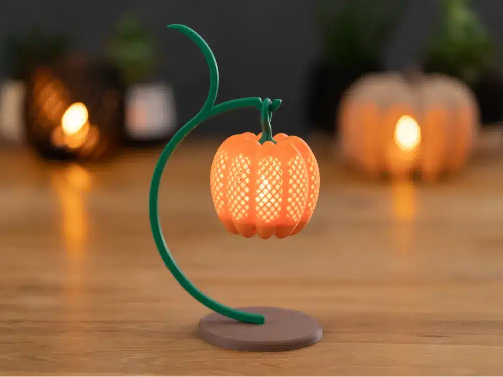 Decorative pumpkin lamp with intricate patterns on a wooden table, creating a warm, cozy ambiance.