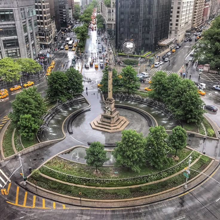 Aerial view of Columbus Circle with traffic and greenery in New York City, featuring iconic monument and urban landscape.