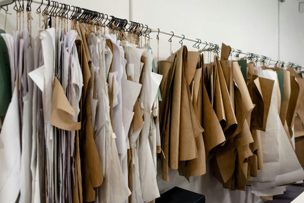 Hanging pattern pieces on a rack, showcasing garment design process in a fashion studio.