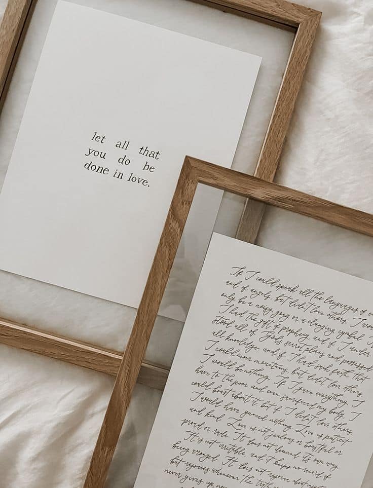 24db38a5-2aeb-4f9e-975c-a30d5aadfd62 Framed motivational quotes on white paper with wooden frames on a bed spread. | Sky Rye Design Framed motivational quotes on white paper with wooden frames on a bed spread.