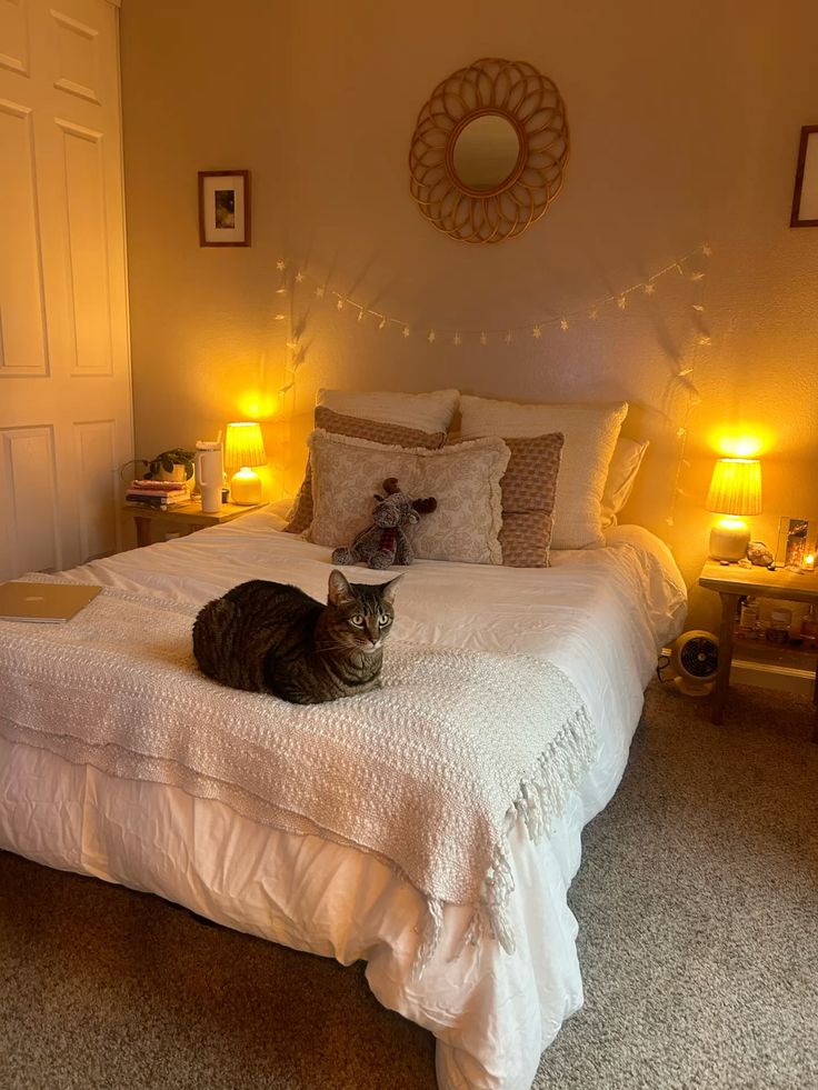 Cozy bedroom with warm lighting, cat on bed, decorative pillows, and string lights for a serene and inviting atmosphere.