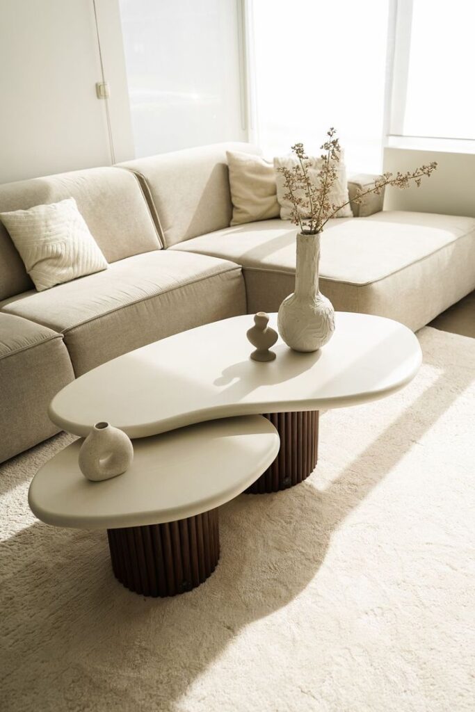 Modern beige living room with stylish coffee table and cozy sectional sofa in natural light.