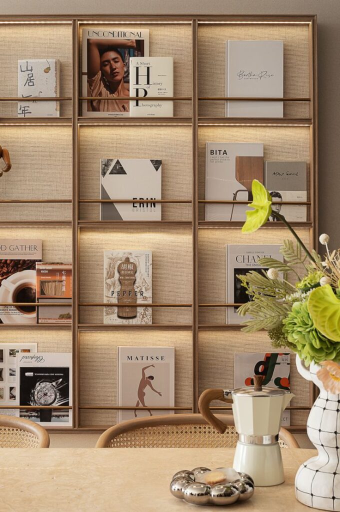 Modern bookshelf with assorted books and decorative items in a cozy, stylish interior setting.