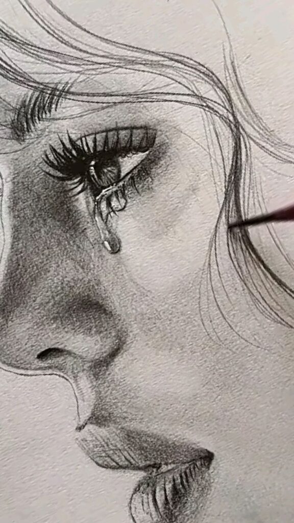 Pencil sketch of a close-up woman's face with a tear, showcasing detailed eye and hair strands.