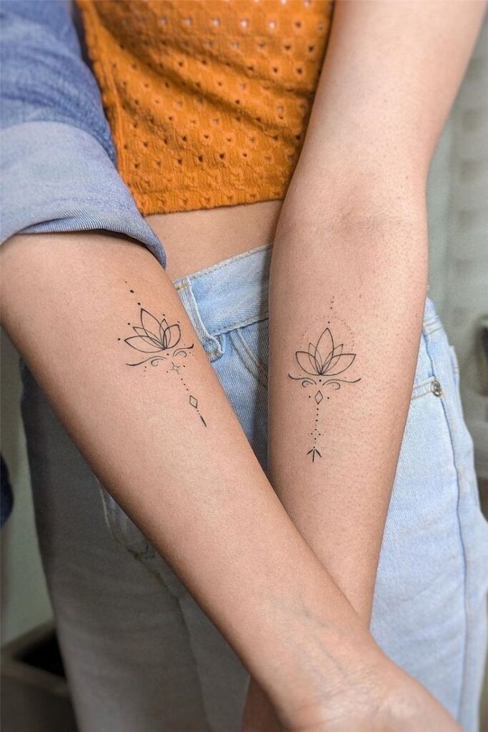Minimalist lotus tattoos on forearms, featuring delicate line art and dots, worn by two people in casual attire.