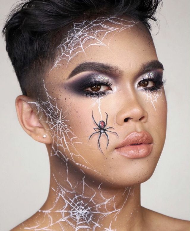 Spooky spider makeup with web designs, featuring dramatic eyeshadow and intricate face art for Halloween.