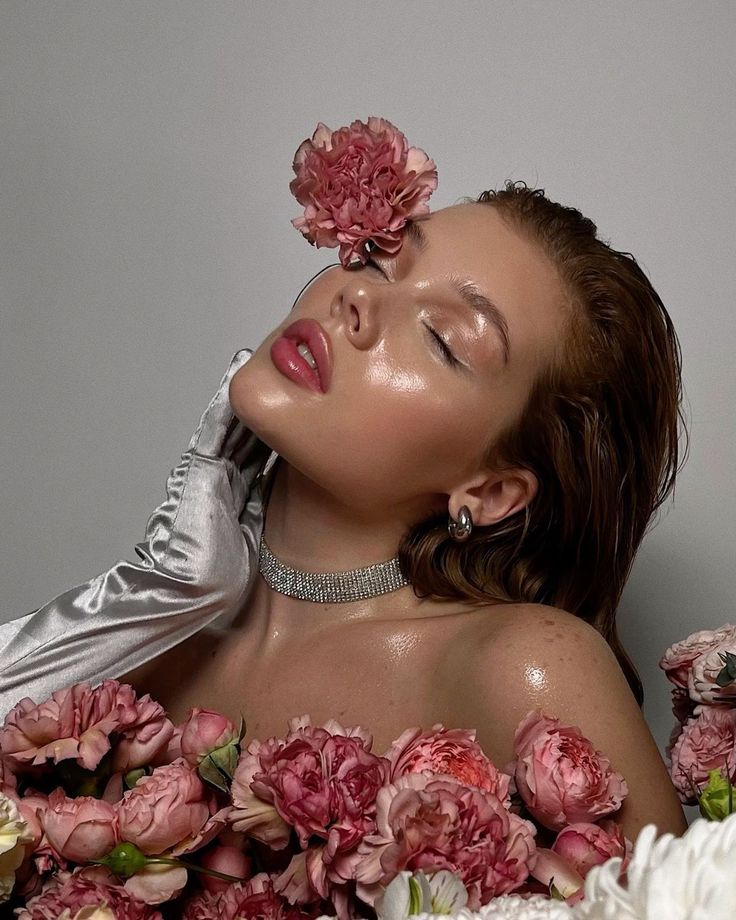 Person in white glove surrounded by pink flowers, embracing beauty and luxury. Elegant, serene, and glamorous aesthetic.