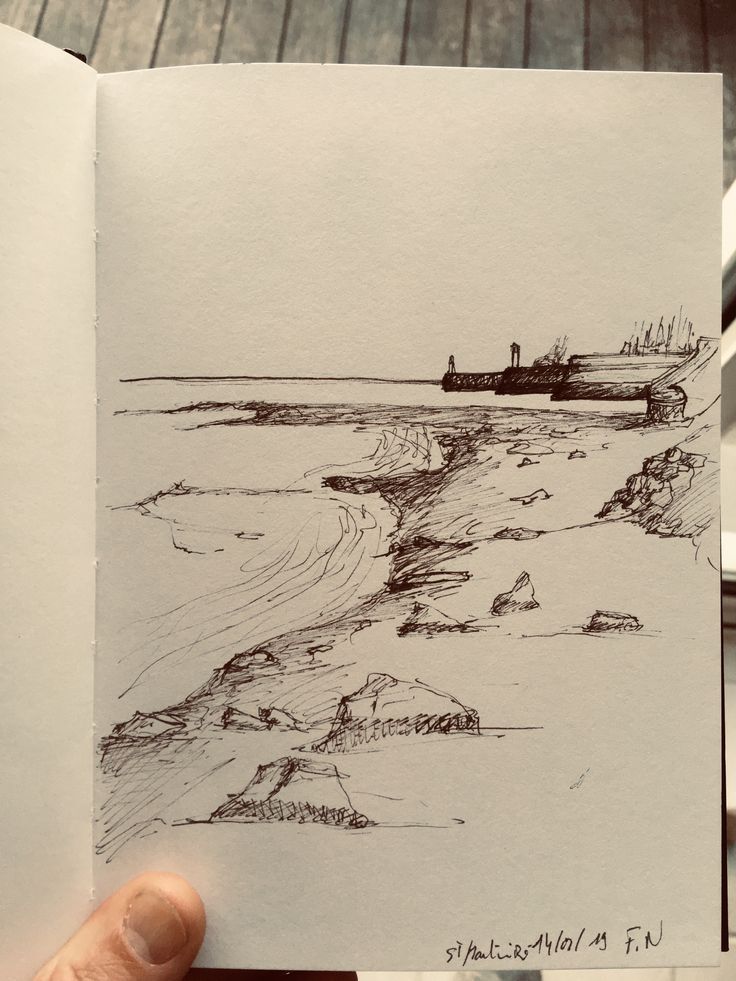 Sketch of a coastal landscape with rocky shore and a distant pier, drawn in pencil on an open notebook page.