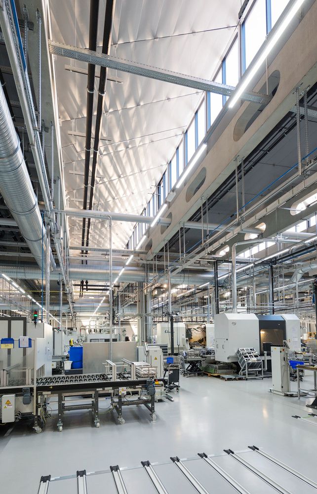 Modern industrial factory interior with advanced machinery and high ceilings, emphasizing efficiency and technology.