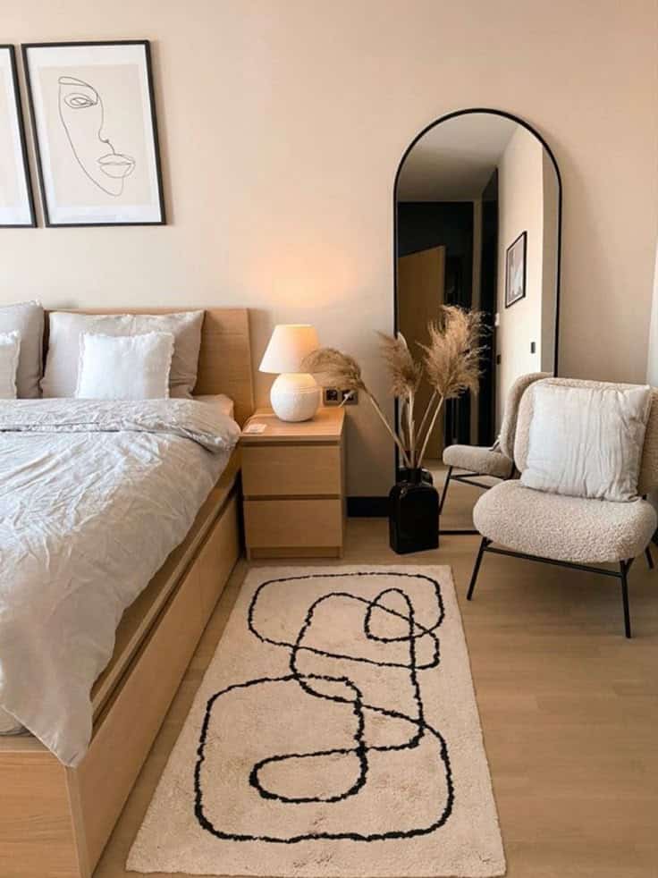 Modern bedroom with minimalist decor, abstract line art, and cozy seating.