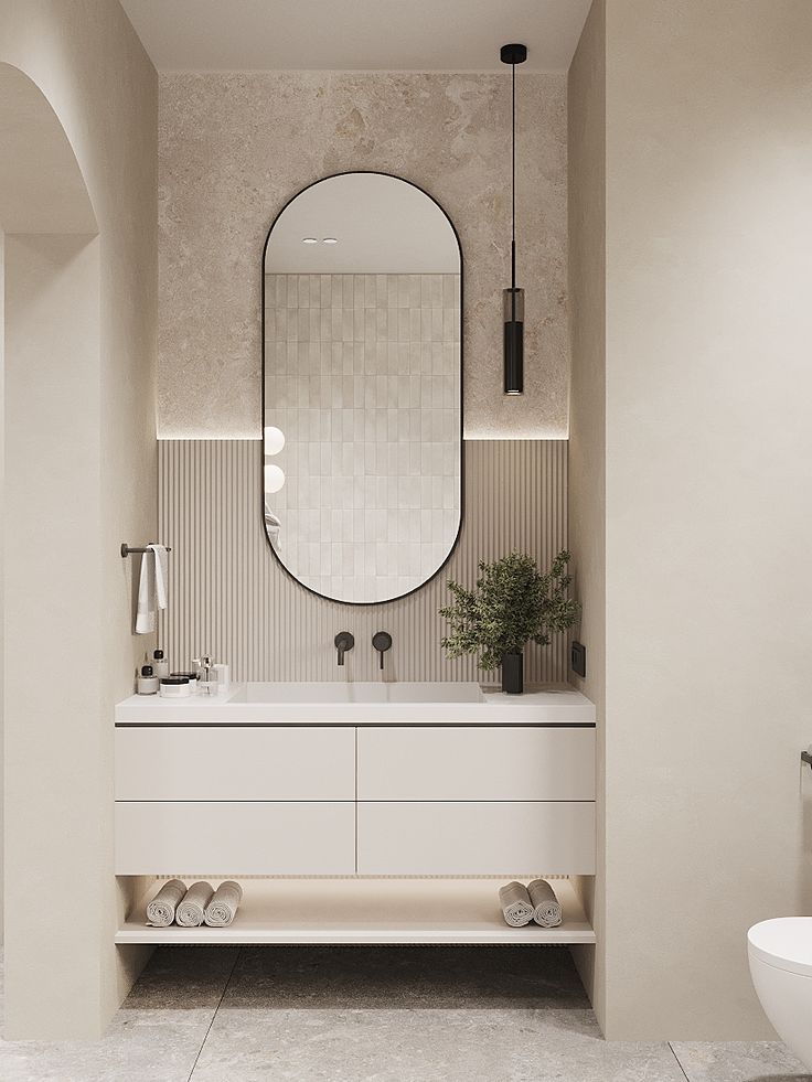 Modern minimalist bathroom with oval mirror, floating vanity, and ambient lighting. Neutral tones create an elegant look.