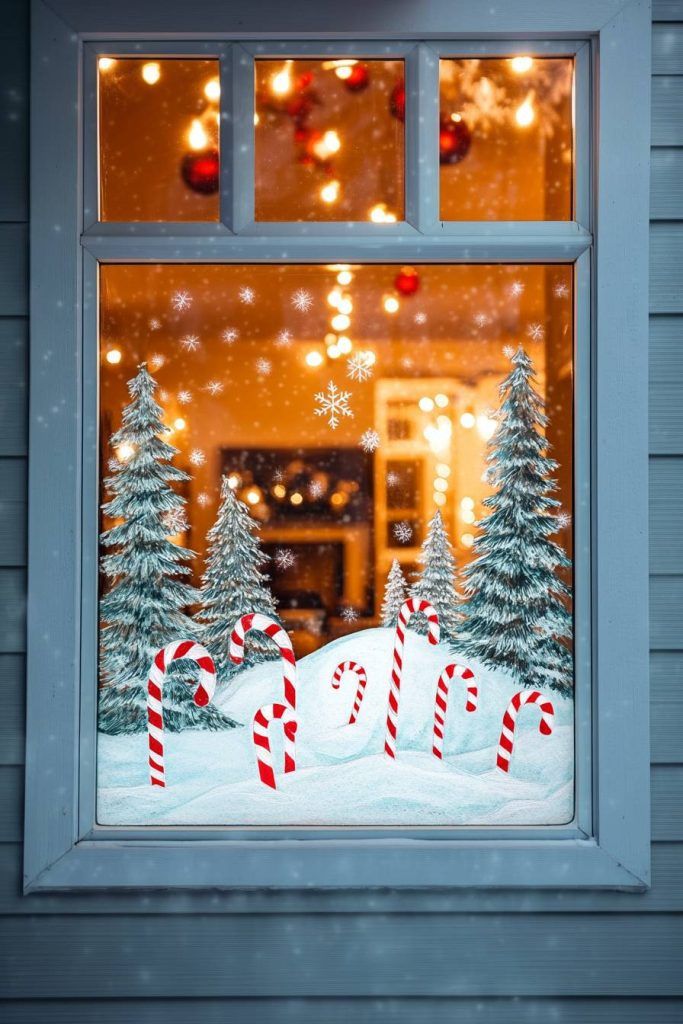 Festive window view with snow, candy canes, and decorated trees glowing under warm, twinkling lights.
