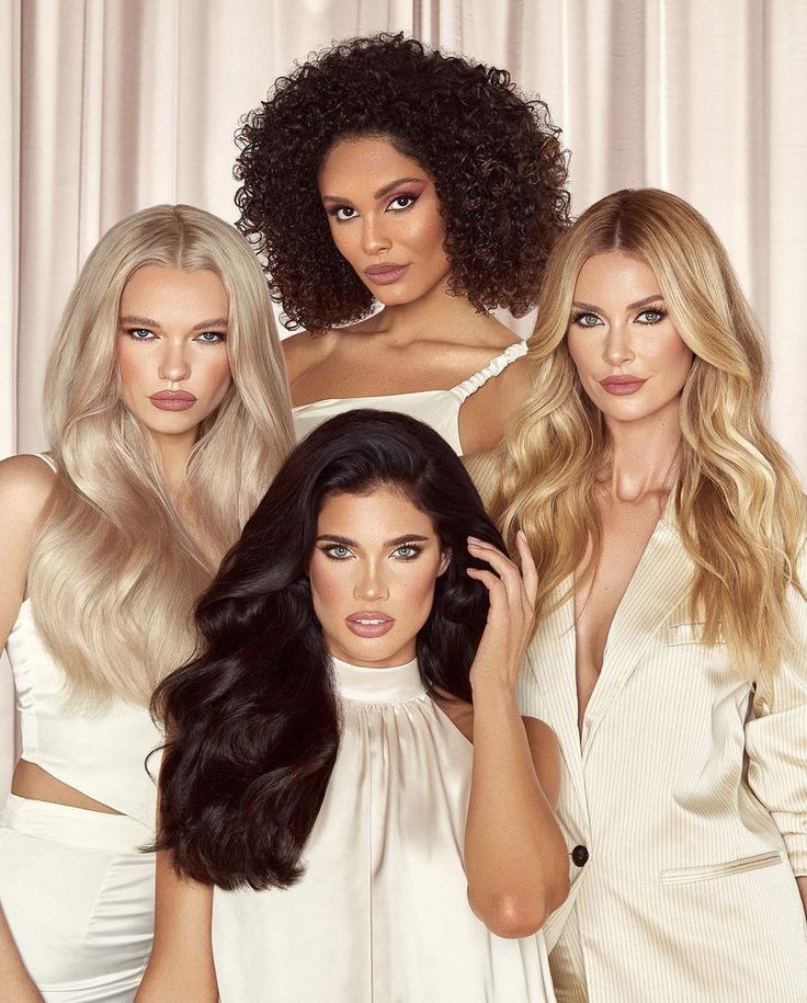 Four women showcasing various hairstyles and colors in an elegant setting, highlighting beauty and fashion trends.