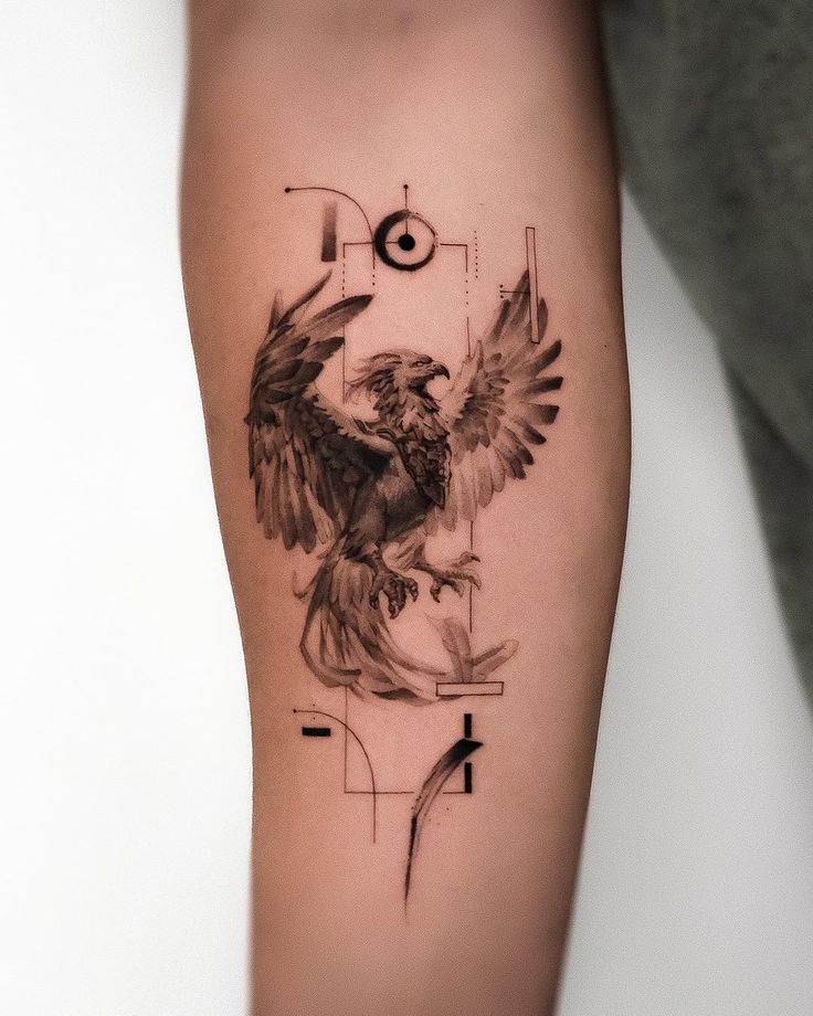 Eagle tattoo design with geometric accents on forearm, showcasing detailed artistry and modern style.