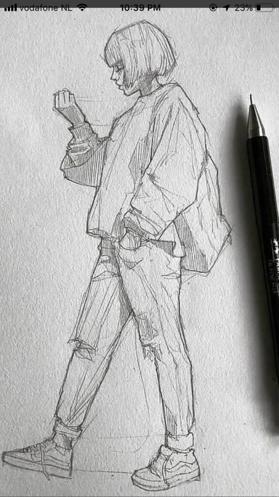 Pencil sketch of a person standing in casual clothing, holding a phone, with a pen laying beside the paper.