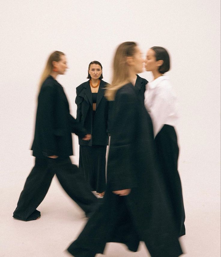 Person standing in focus as others walk past in blurred motion, highlighting contrast and stillness amid movement.