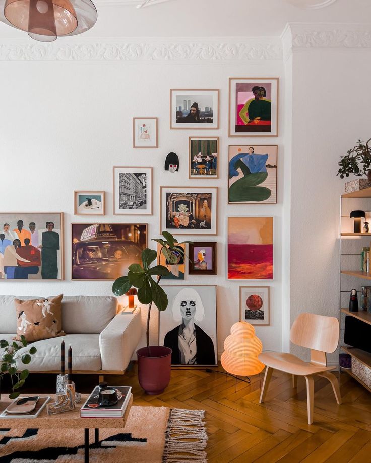 Gallery wall in stylish living room with modern art, cozy sofa, wooden flooring, and vibrant decor elements.
