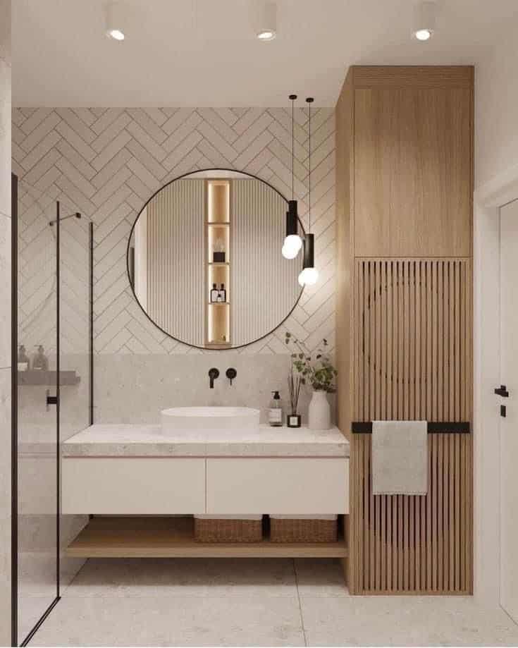 Modern bathroom with round mirror, wooden accents, white vanity, and elegant lighting. Minimalist and stylish design.