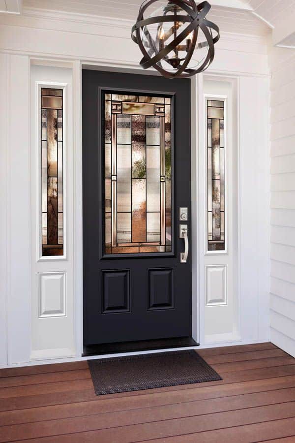 Black front door with decorative glass panels, flanked by sidelights, under modern chandelier on wooden porch.