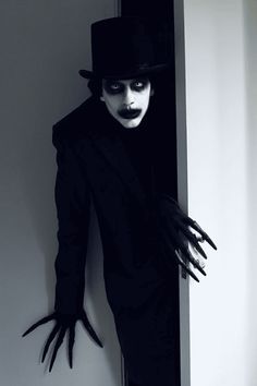 Spooky character in dark attire and top hat lurking through doorway with long, eerie fingers. Halloween or horror theme.